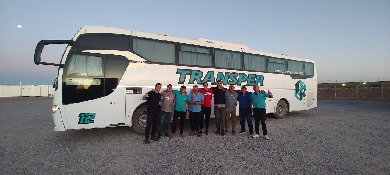 Equipo de Transper frente a un micro de la empresa